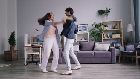 happy couple dancing in living room
