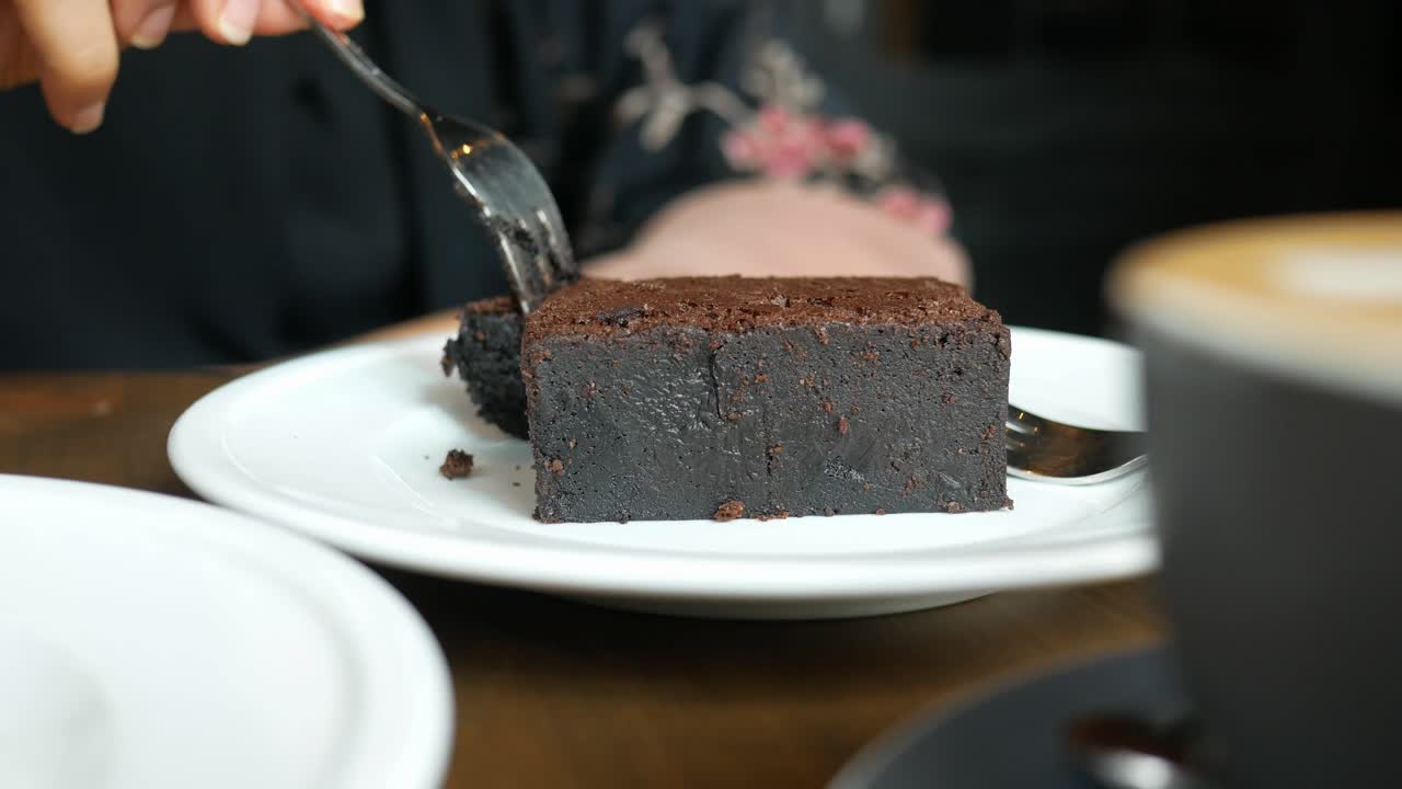 카페에서 초콜릿 브라우니를 먹는 여자