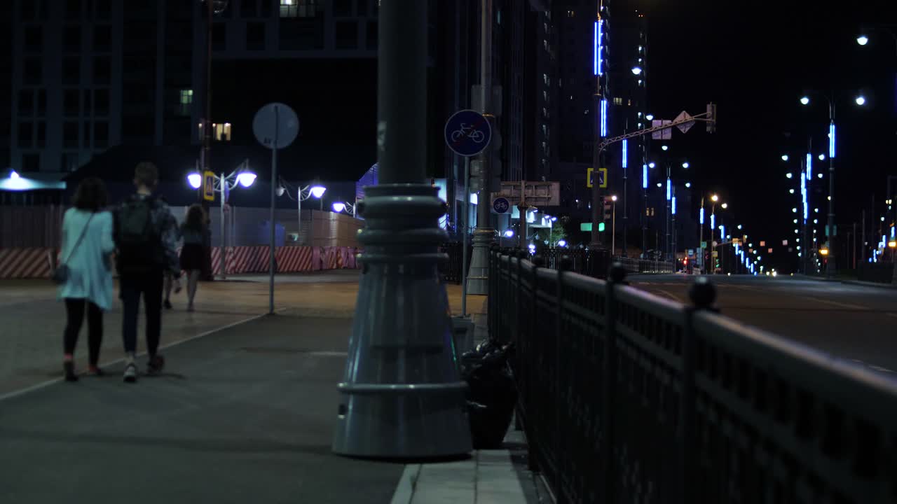 City Street at Night with People Walking