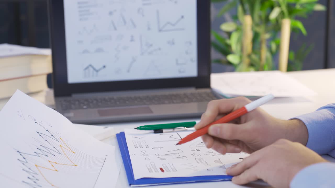 hombre de negocios trabajando con gráficos de análisis y usando computadora portátil.