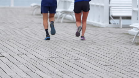 Beine-Von-Menschen,-Die-Auf-Der-Promenade-Mit-Bänken-Laufen