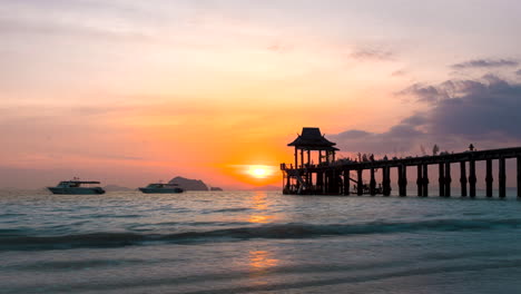 Thai-beach-day-to-night-time-lapse---sunset-view-over-ocean-with-boats-and-pier