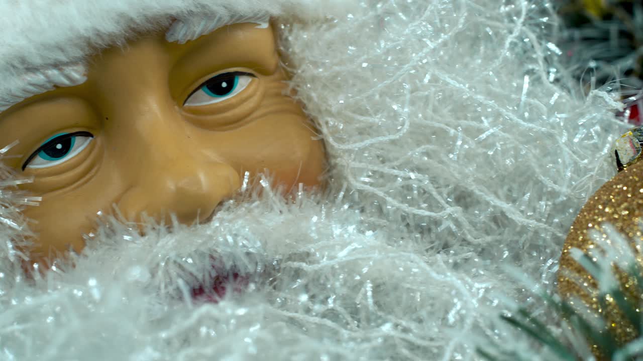 세부적인 클로즈업 매끄러운 판 오른쪽, 벨과 함께 빨간 모자를 입은 산타클로스 장난감, 크리스마스 장식, 전통적인 휴가 선물, 새해 장식, 레트로 선물, 4k 비디오