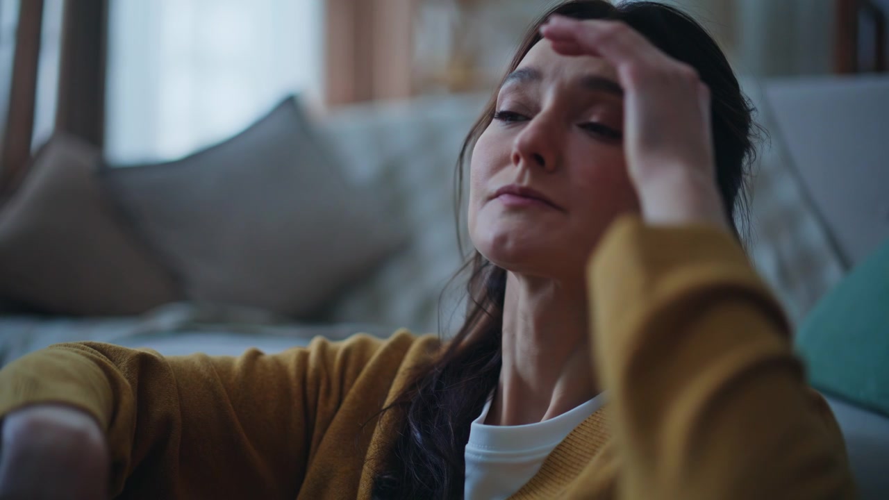 Signora turbata che guarda lo smartphone leggendo cattive notizie, seduta sola la sera, primo piano.