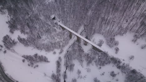 Stunnig-aerial-shot-showing-an-old-train-viaduct-with-a-tunnel-entering-through-the-mountain-at-the-end-of-it