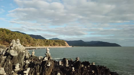 Antena:-Dron-Volando-A-Baja-Altura-Alrededor-De-Montones-De-Rocas-Junto-Al-Océano-En-El-Extremo-Norte-De-Queensland,-Australia