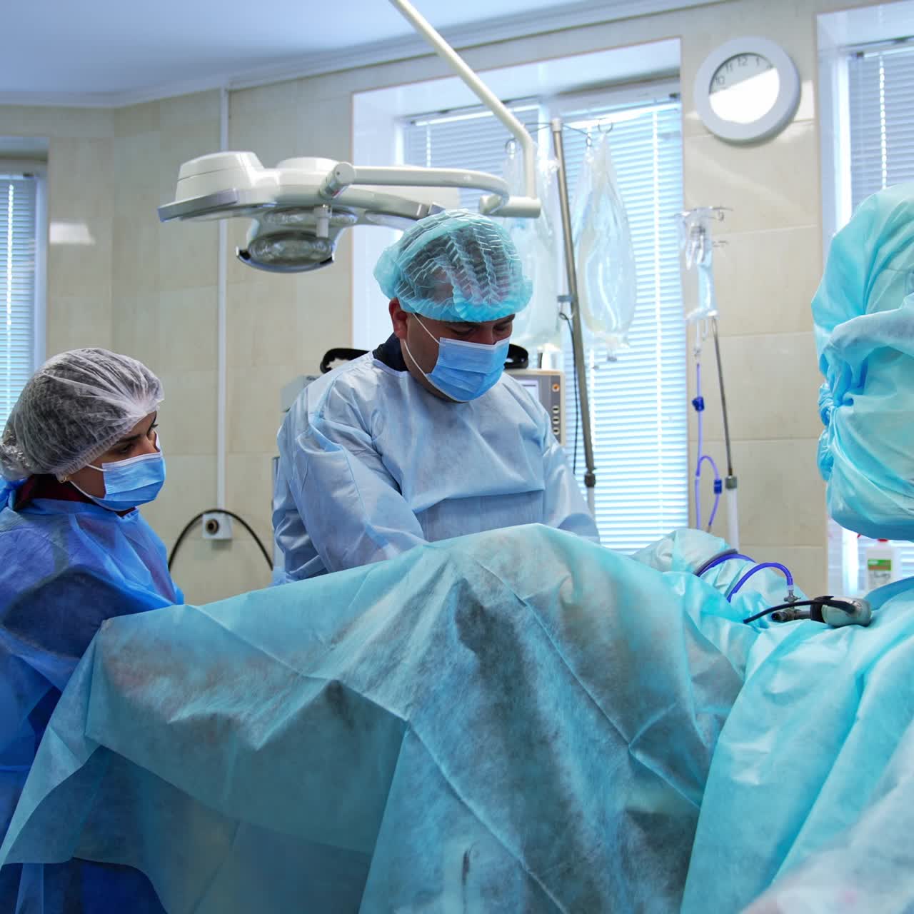 Surgeon operates the patient assisted by a female nurse. Gradual distancing from a patient on a surgery table