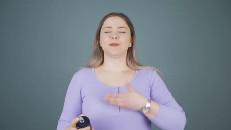 la joven que se pone perfume y huele bien.
