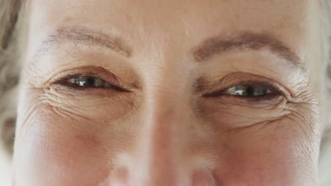 retrato de cerca de los ojos de una feliz mujer caucásica mayor sonriendo, en cámara lenta.
