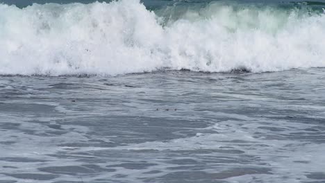 múltiples olas pequeñas que se reforman en la playa de aguas bravas