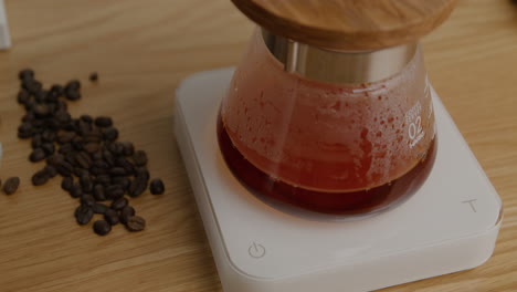 Filtered-drip-coffee-dripping-into-v60-flask-with-coffee-beans-on-the-side