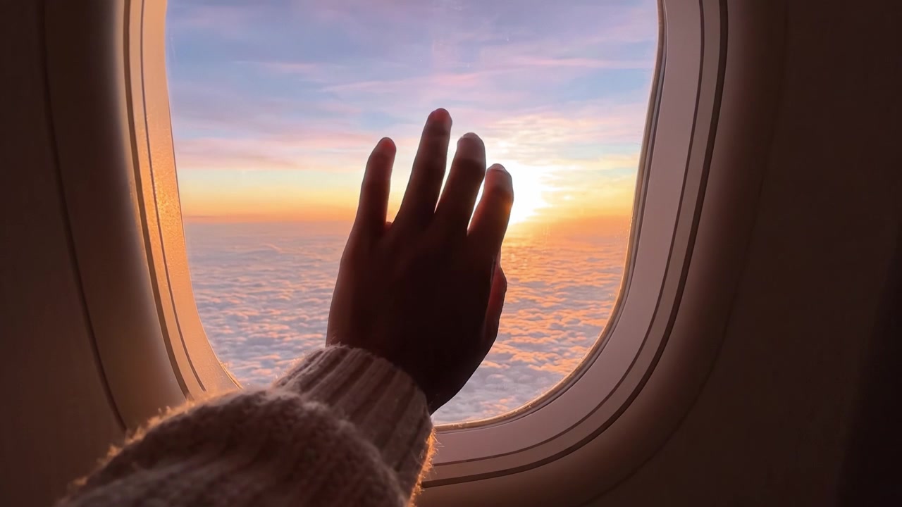 Captivating Sunset View from an Airplane Window: Witness the Serenity and Beauty of Nature Above the Clouds as Day Transitions to Night.