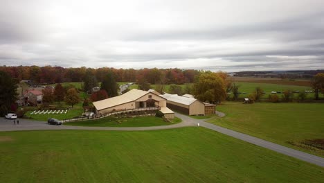 Aerial-establishing-shot-of-a-converted-barn-wedding-venue-in-Hamburg,-Pennsylvania-in-the-fall