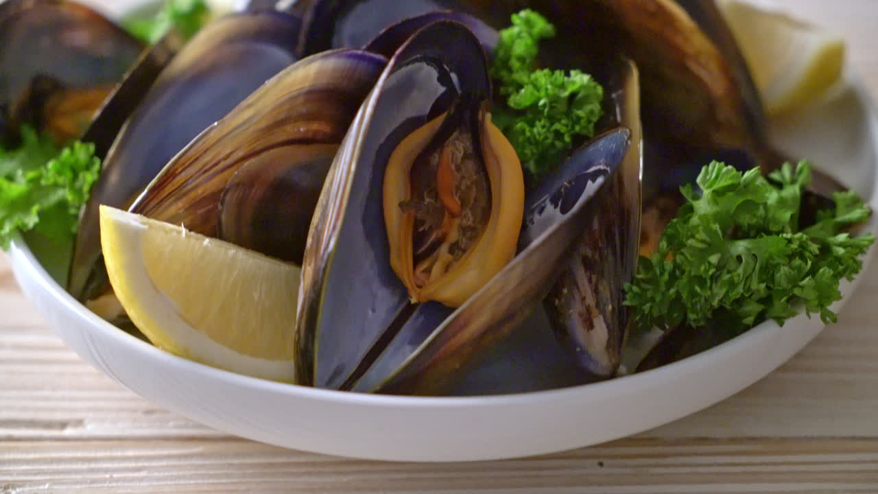 レモンとボウルにハーブと新鮮なムール貝