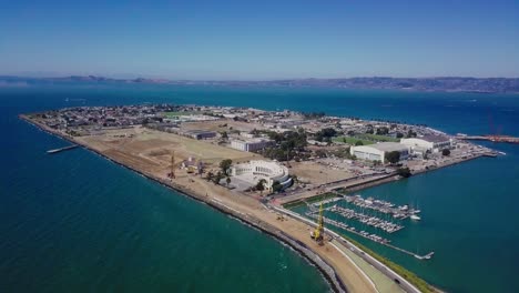 4k aerial drone view of treasure island san francisco bay area surrounded by turquoise blue ocean sea water waves camera fly up