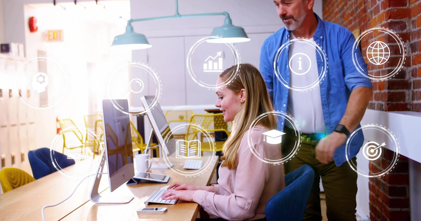 Donna di mezza età che digita sullo schermo, con icone che appaiono e un collega che si unisce a una discussione di e-learning.