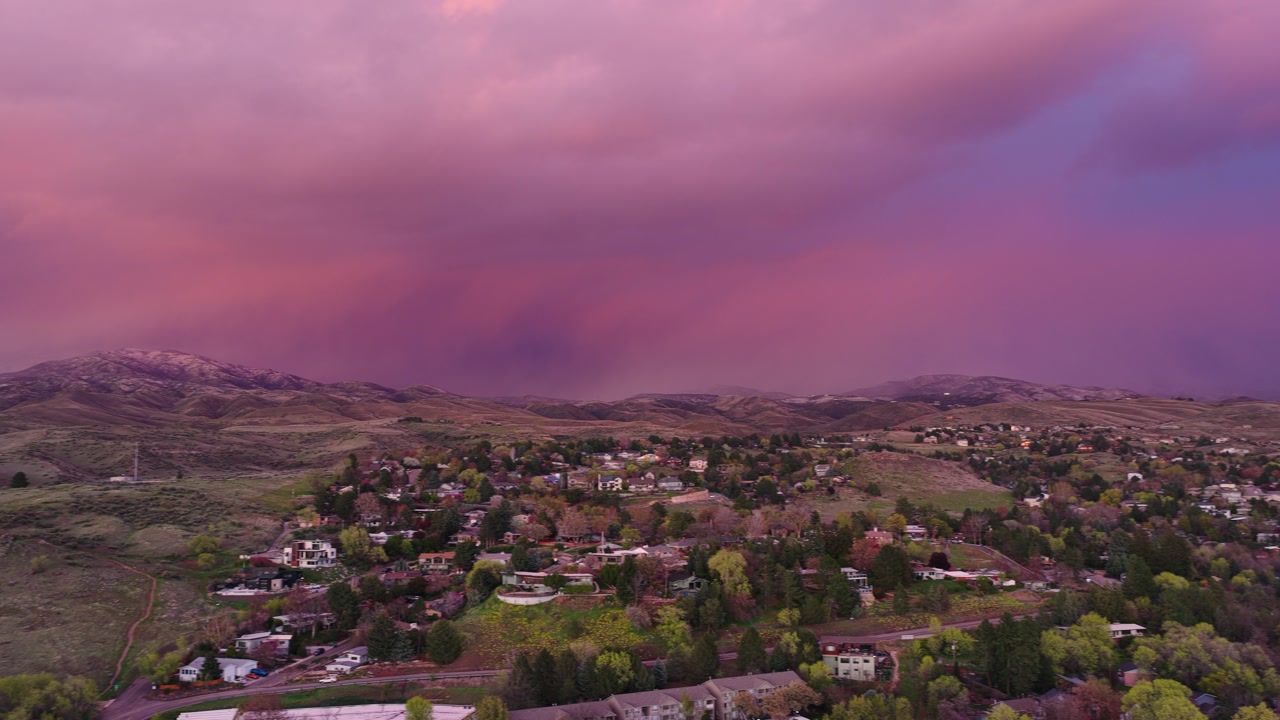 Wide shot across foothills of sunset clouds