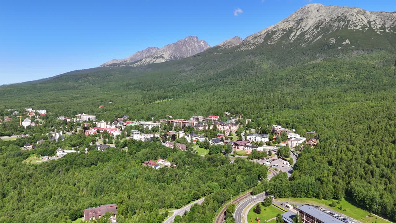 Aerial drone shots of the picturesque town of Starý Smokovec nestled in the High Tatras Mountains, Slovakia. The footage showcases panoramic views of rugged peaks, dense forests, and mountain resorts
