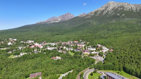 aerial drone shots of the picturesque town of starý smokovec nestled in the high tatras mountains, slovakia. the footage showcases panoramic views of rugged peaks, dense forests, and mountain resorts