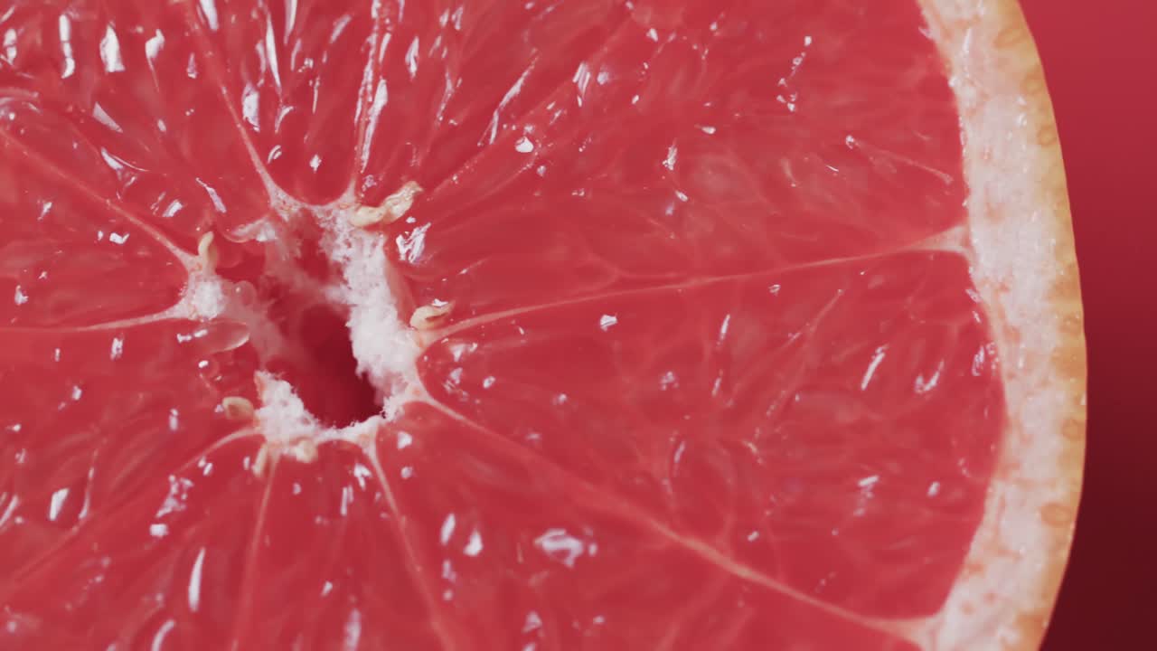 Video di pompelmo rosso affettato con spazio per il testo su sfondo rosso