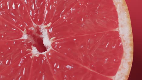 Video-Von-Geschnittener-Roter-Grapefruit-Mit-Kopierraum-Auf-Rotem-Hintergrund