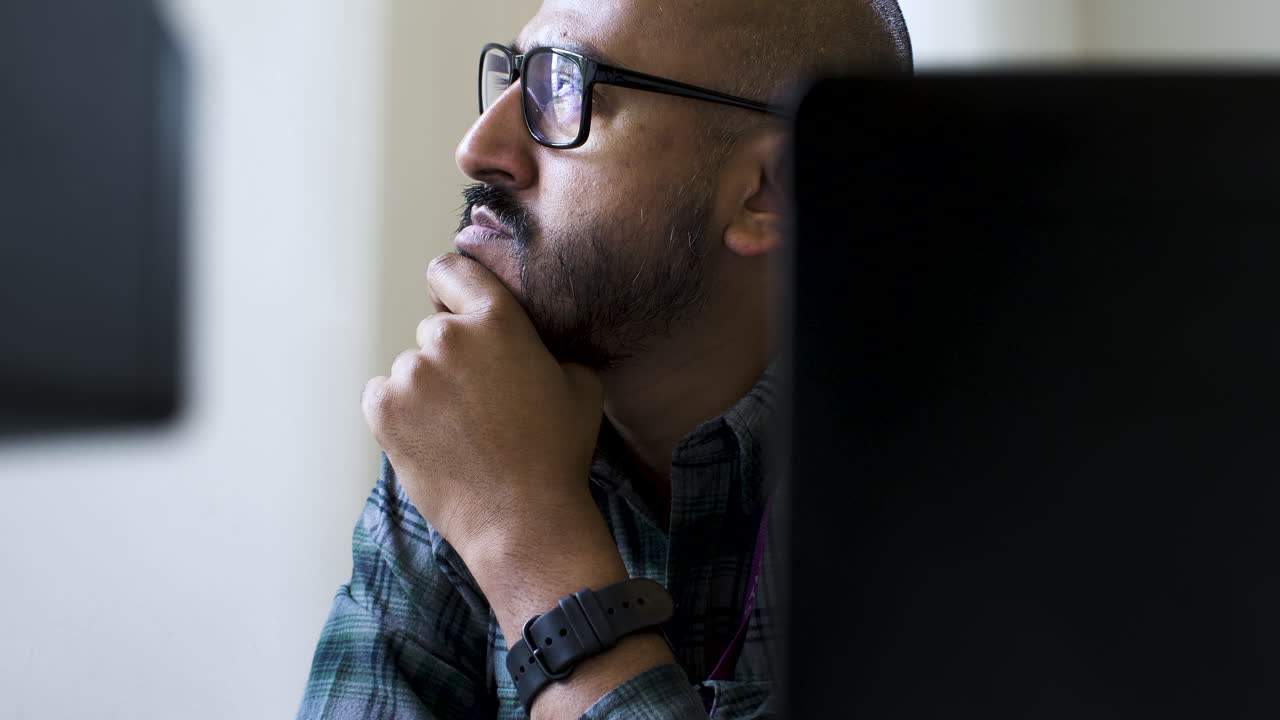 hombre de negocios cansado sentado en la computadora, reflejo de luz azul en las gafas