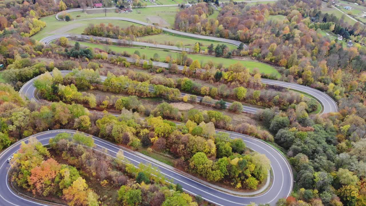 curvas de la carretera sinuosa a través del bosque de otoño en la polonia rural panorama aéreo