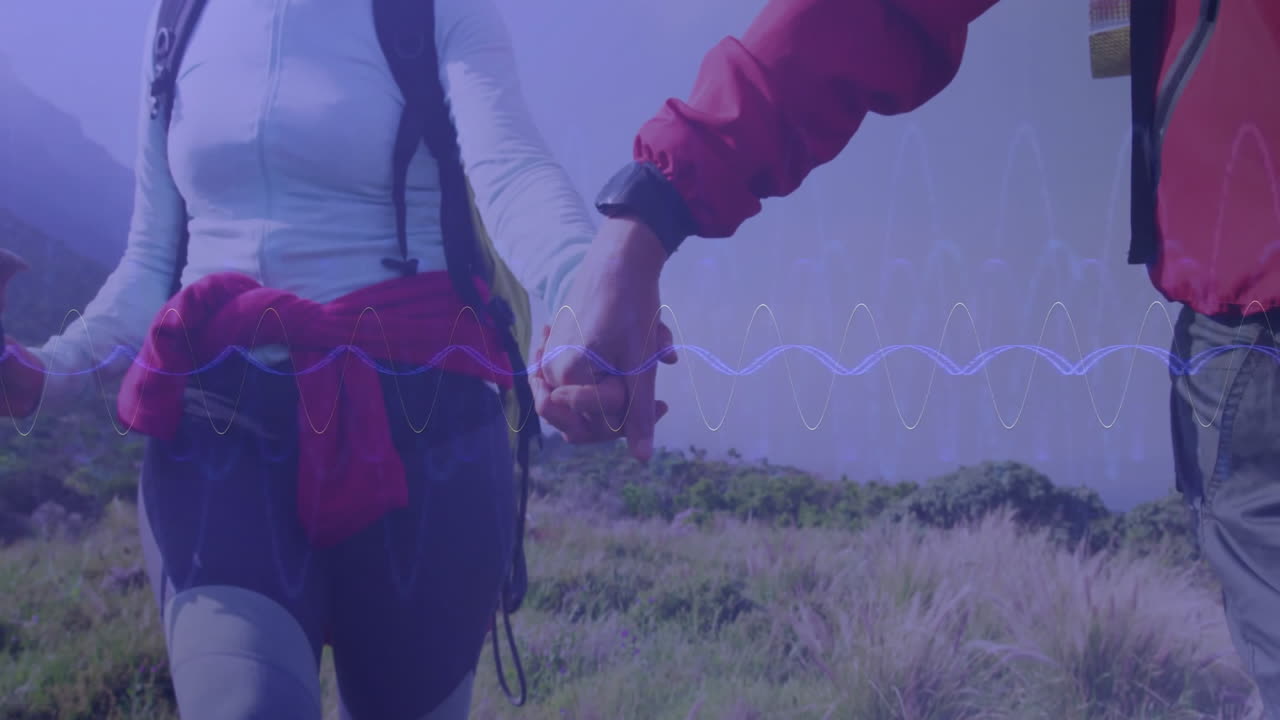 Couple walking hillside trail, illustrating audio waveform overlay for technology