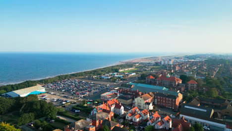 Explore-Skegness,-Lincolnshire,-from-above-in-this-captivating-aerial-video,-featuring-its-vast-beach,-vibrant-tourist-attractions,-and-the-iconic-pier-on-a-summer-evening