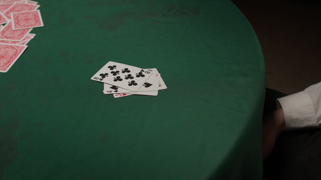 el jugador derrotado arroja su mano perdedora en un oscuro casino malhumorado