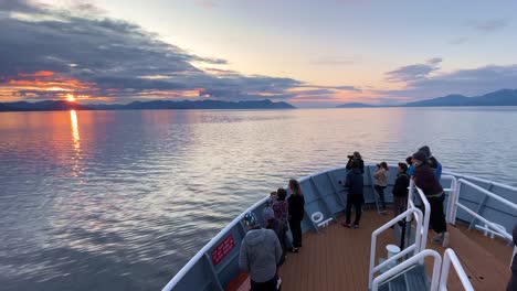 touristen auf einem kreuzfahrtschiff in stephens passage, alaska, fotografieren den sonnenuntergang