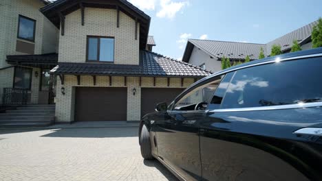 man driver in car thumbed remote control to open the garage door in the house