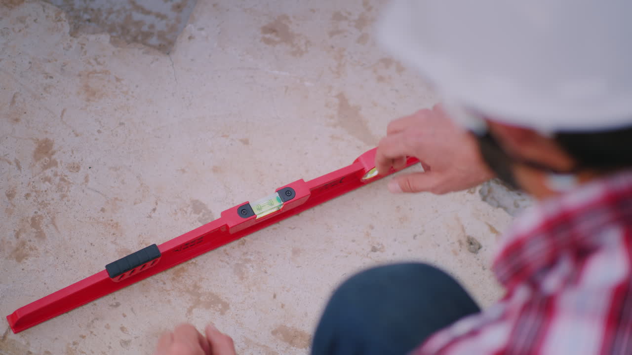 el joven ingeniero comprueba la precisión del trabajo en la construcción de la fundación inspecciona th