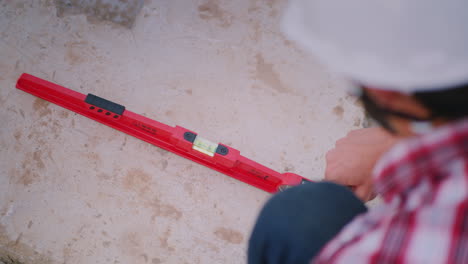 the young engineer checks the accuracy of the work on the construction of the foundation inspects th