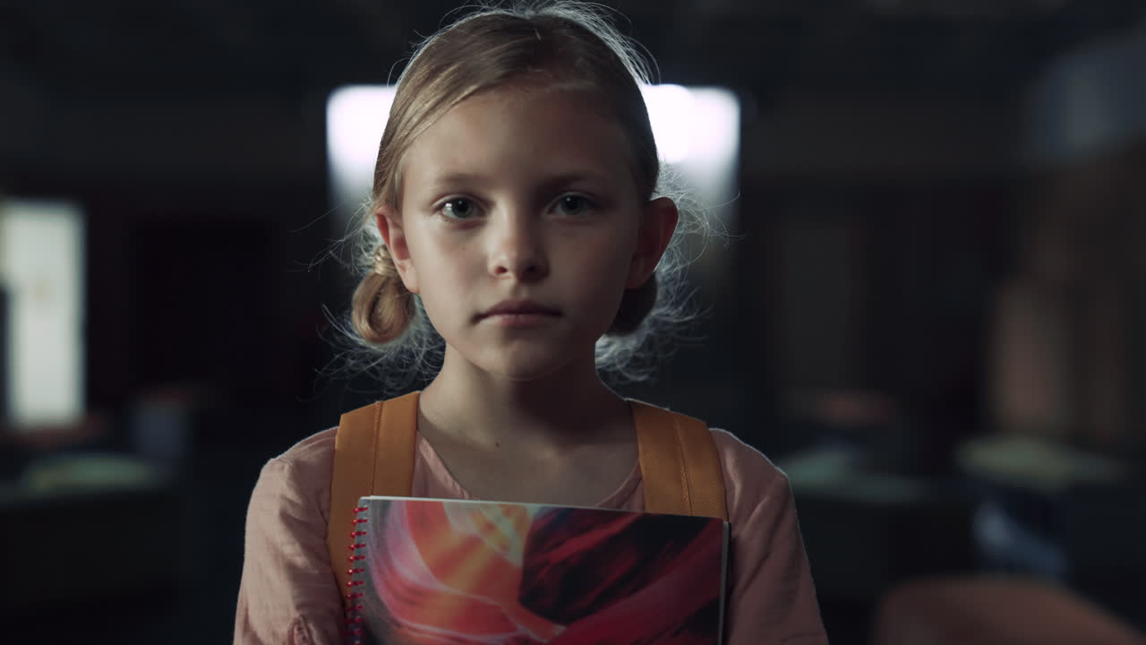 교실에서 노트북을 들고 서 있는 화가 난 여자. 겁에 질린 여학생