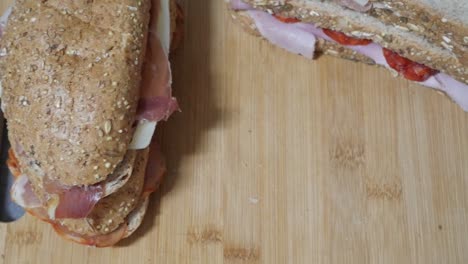 panado de sándwiches en tabla de corte de madera y plato