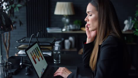 Businesswoman-working-on-laptop-at-office.-Employee-using-smartphone