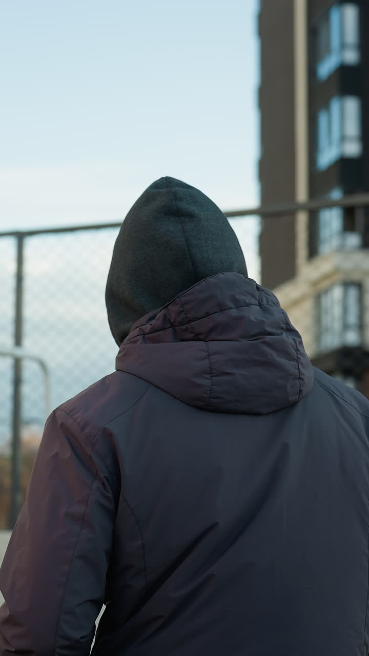 도시 건축물과 근처에서 는 사람들로 둘러싸인 야외 스포츠 경기장에서 골포스트와 함께 조하는 선수