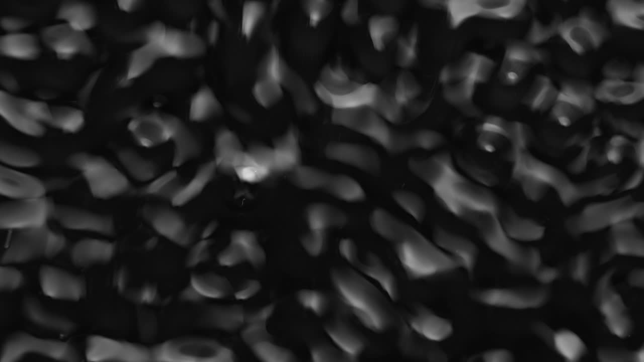 Splashes and drops on the surface of the liquid. Abstract Black Background Water vibration