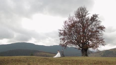 Lovely-newlyweds-bride-groom-dancing-on-mountain-autumn-slope-in-slow-motion,-wedding-couple-family