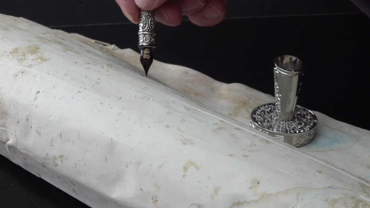 человек, пишущий пером на пергаментной бумаге