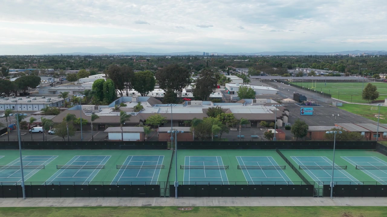 Ampia ripresa aerea con dolly di campi da tennis in una scuola superiore nella California meridionale. 4K.