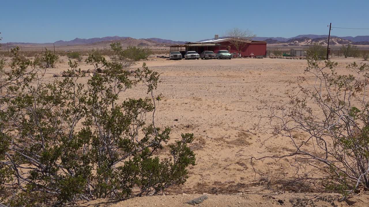 viejos autos cadillac clásicos y otros autos antiguos se sientan afuera de una casa de campo remota en el desierto de mojave 1