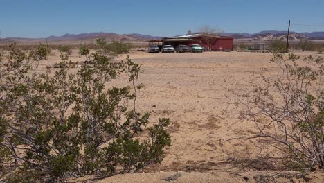 viejos autos cadillac clásicos y otros autos antiguos se sientan afuera de una casa de campo remota en el desierto de mojave 1