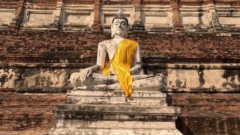 turistas que visitan una histórica estatua de buda en ayutthaya.