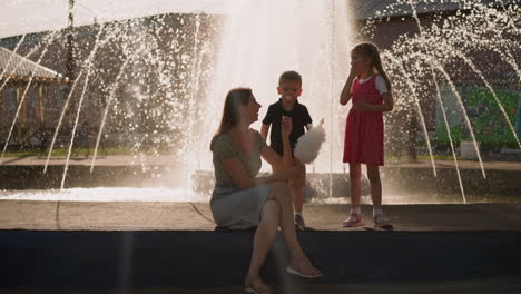 woman treats children with spun sugar against waterworks