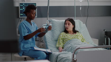 primer plano de la enfermera afroamericana explicando la radiografía de huesos