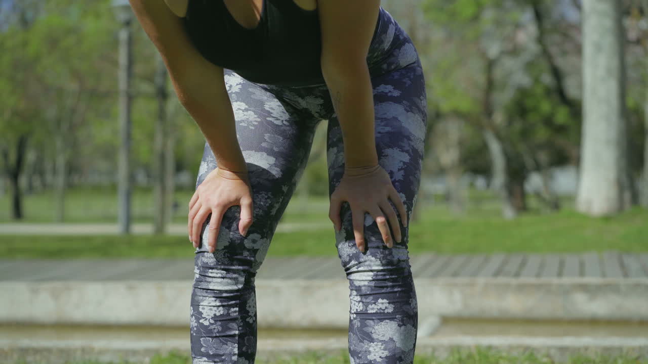 꽃 레 ⁇ 을 입은 여성의 다리가 구부러져서 휴식을 취하고 있습니다.