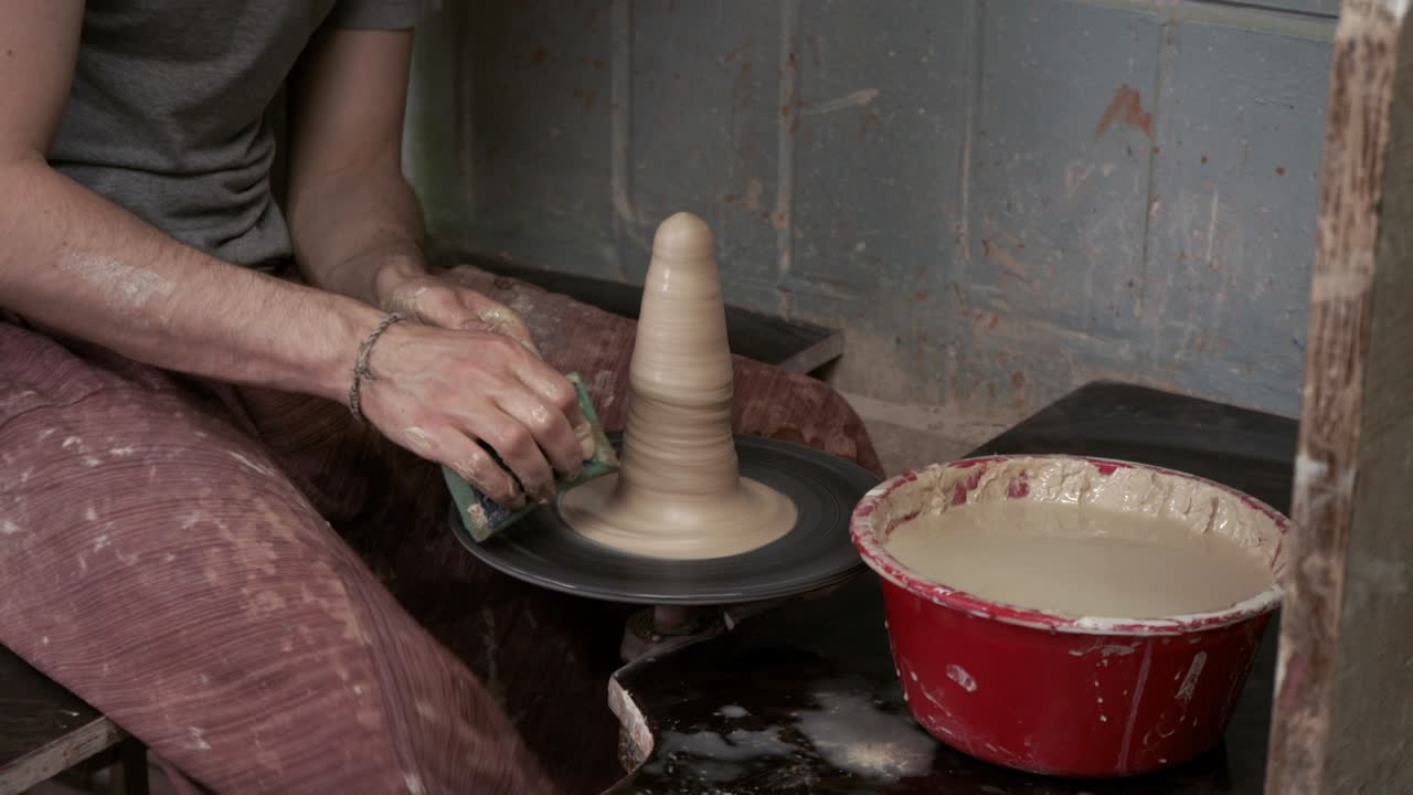 Il vasaio crea una brocca di argilla. Ceramista. Un uomo realizza un vaso al tornio da vasaio.