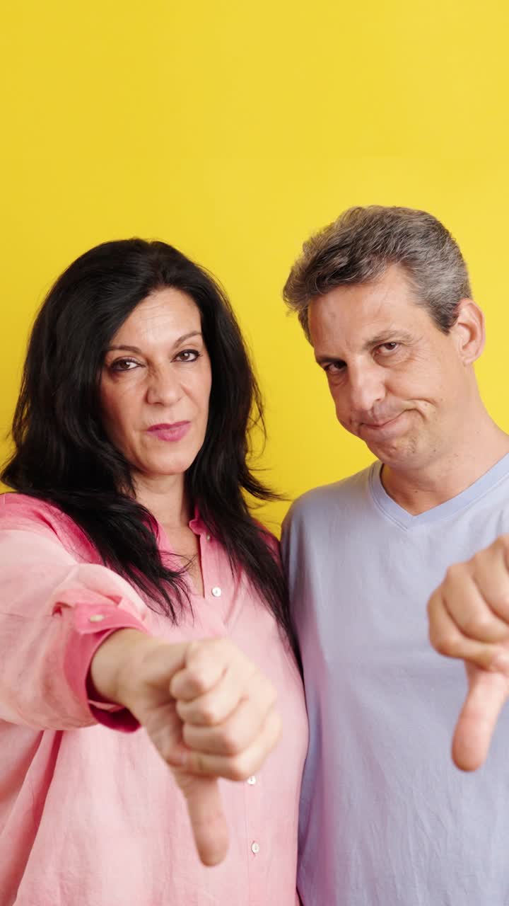 Couple Showing Thumbs Down in Disapproval